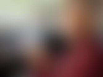 Um senhor ou senhora (acima de 60 anos) sorridente, sentado(a) ao volante de um carro moderno, em um ambiente claro e ensolarado.